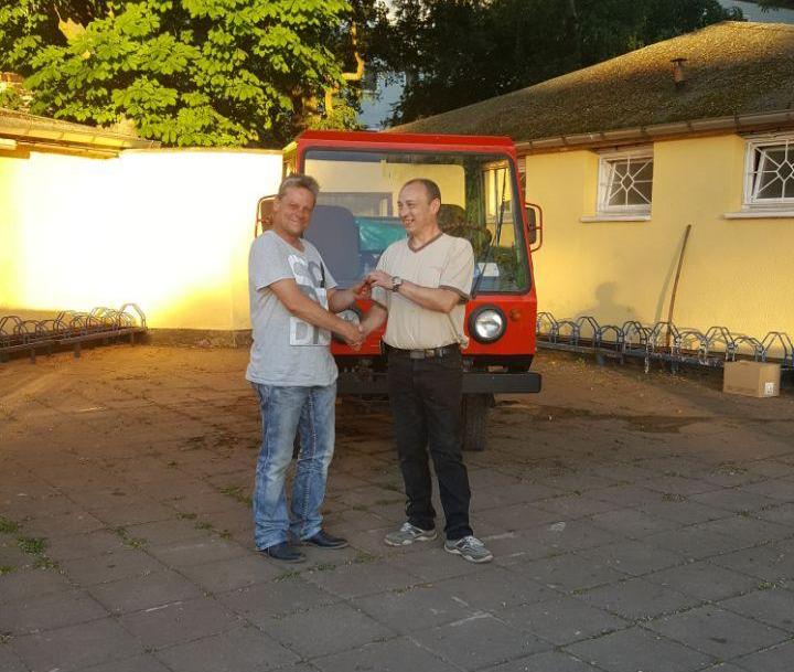 Foto: Sven Gierloff (links im Bild) bei der Übergabe des Schlüssels des frisch restaurierten Multicars der SG